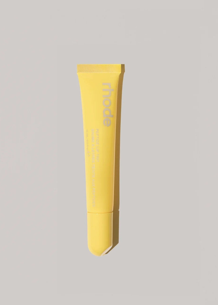 Yellow tube of cream on a gray background